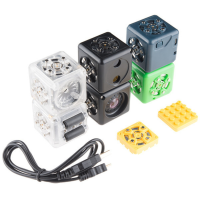 There are 6 plastic blocks, two white, two black, one navy, and one green. There is a USB cable, as well as two yellow squares.